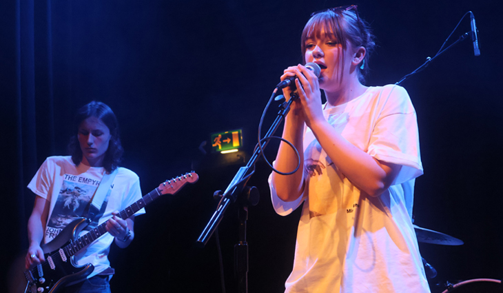 Female music student singing at Introducing Nights even with male guitar player in the background