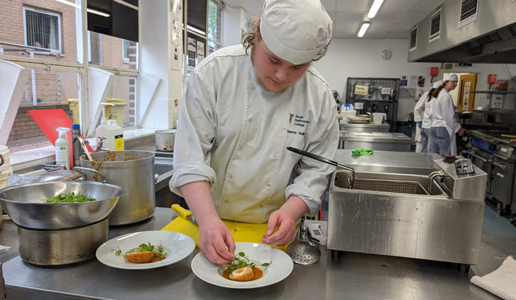 Photo of Catering student Warren adding garnish to scotch egg dish