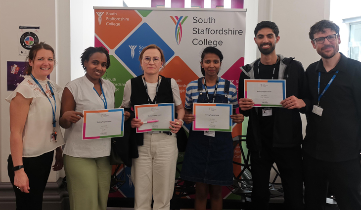 Group of ESOL students holding certificates with staff at Cannock College